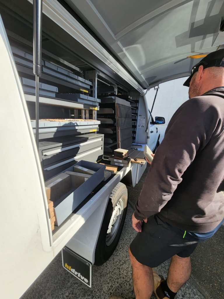 Modinex worker grabbing materials from the ute